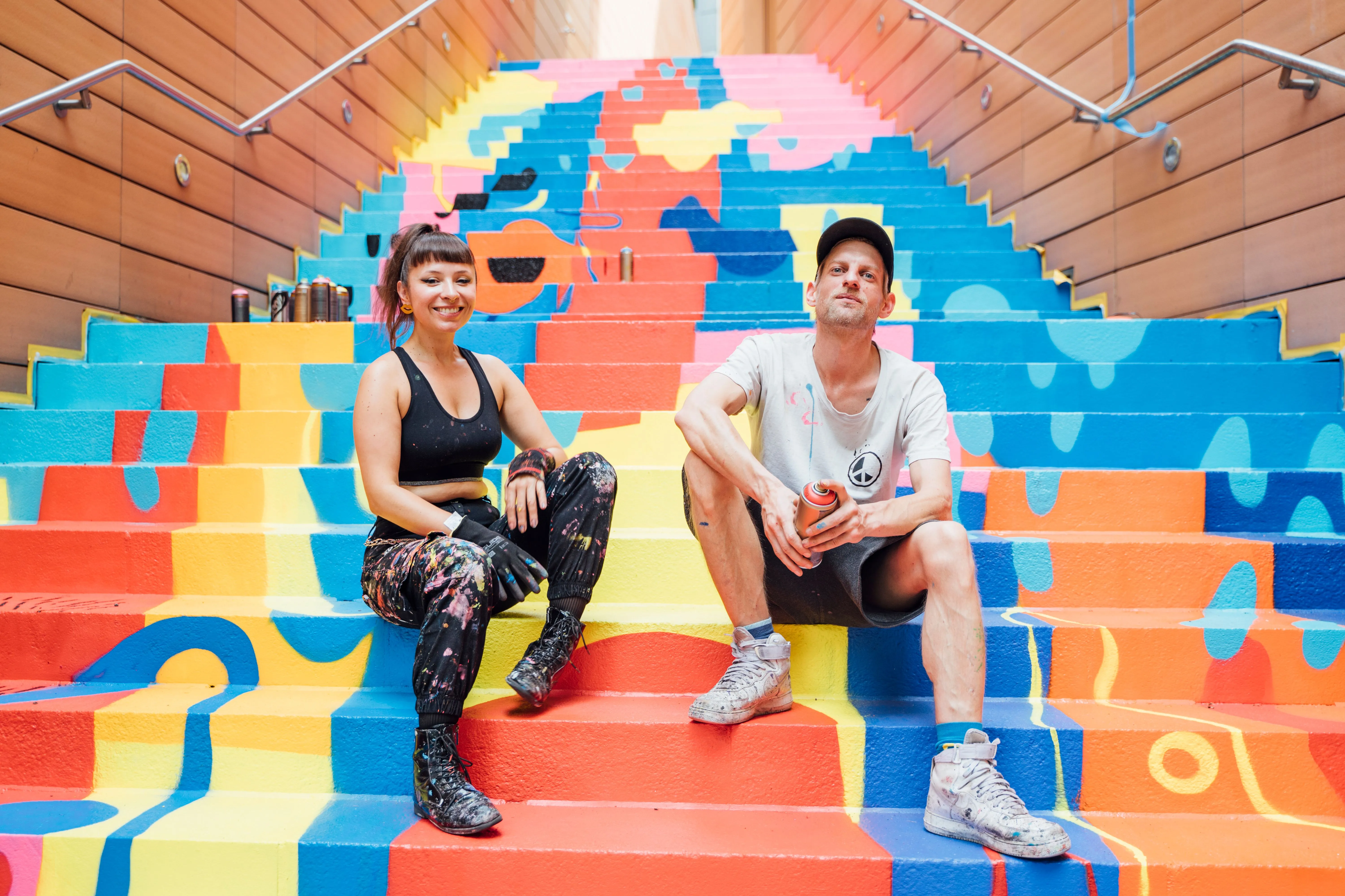 Künstlerin Carolina Amaya sitzt auf Treppen-Kunstwerk BLOOOOM!